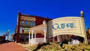 Historic building with a sign for Guthrie, Oklahoma, under a clear blue sky.